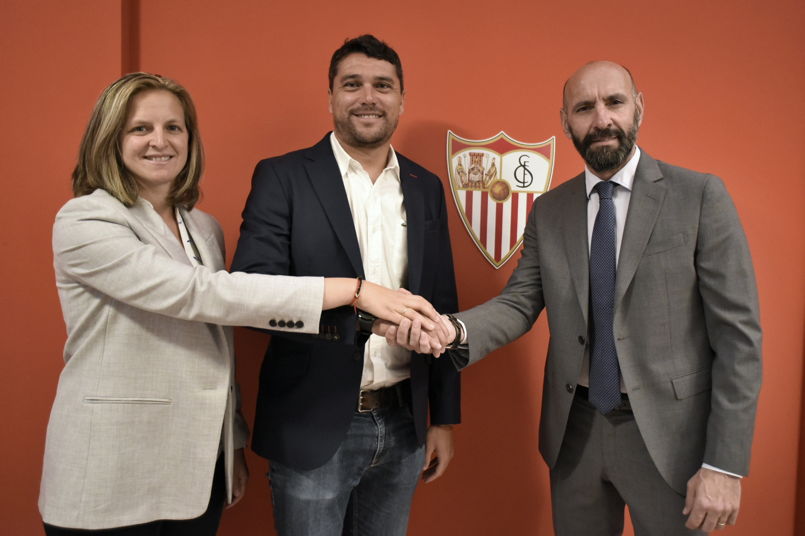 Cristian Toro, en la firma de su renovación como entrenador del primer equipo femenino del Sevilla FC, posa acompañado por Amparo Gutiérrez y Ramón Rodríguez Verdejo, Monchi