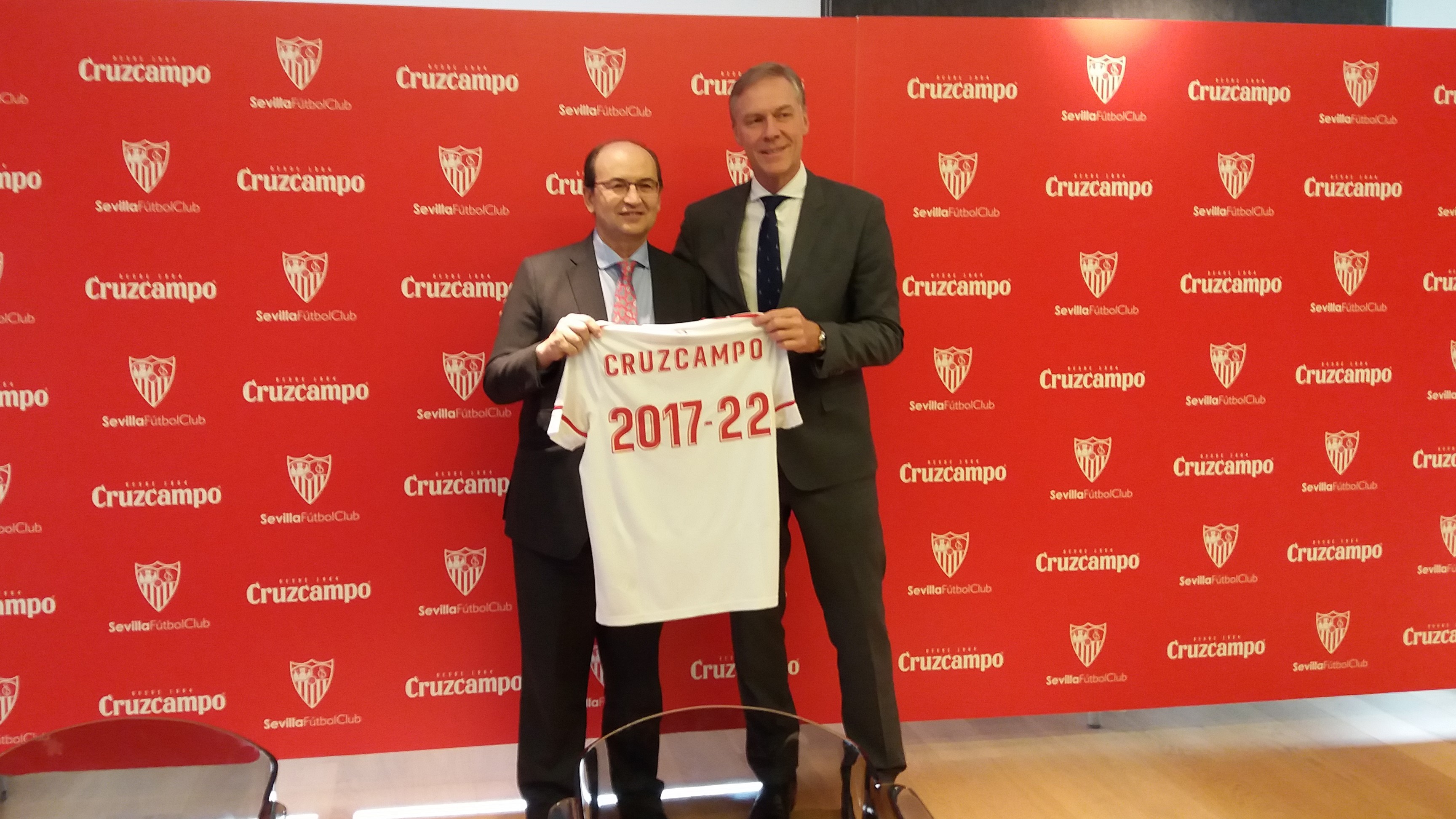Los presidentes del Sevilla FC y de Heineken España, a la que pertenece Cruzcampo, posan con una camseta con la duración del acuerdo 