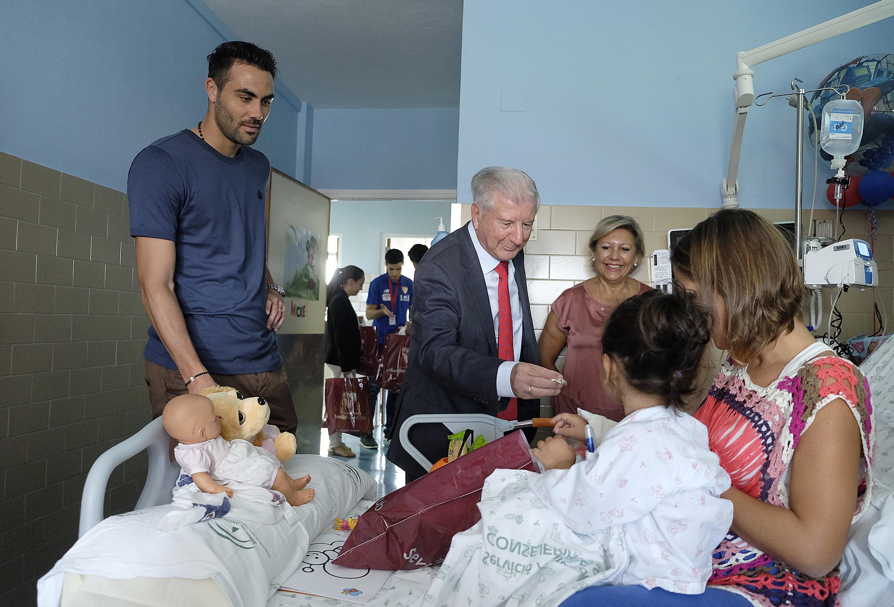 Vice-President Gabriel Ramos and the Sevilla FC captain Iborra give a gift to a girl