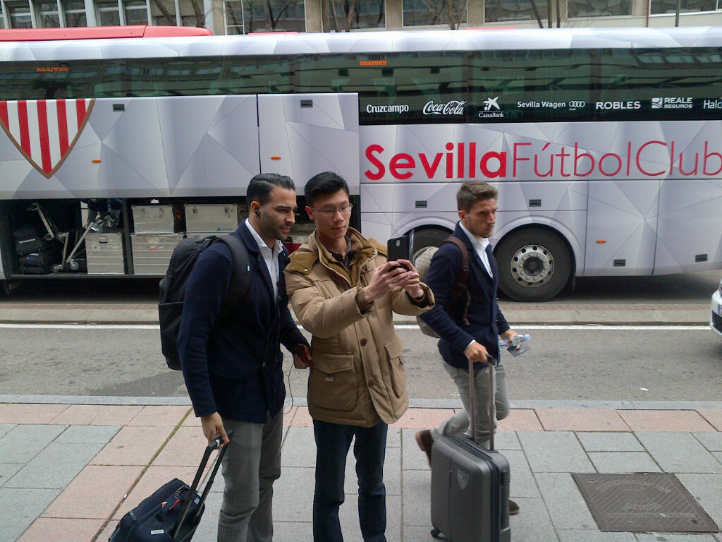 Un aficionado se fotografía con Ramí delante del bus oficial