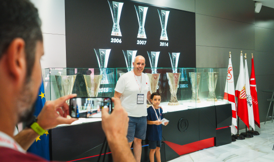 Unos visitantes se fotografían junto a las siete copas de la Europa League.