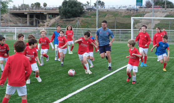 Jugadores del Sevilla Atlético jugando con alumnos de la Escuela Antonio Puerta.