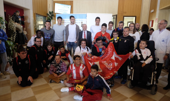 La expedición sevillista en San Juan de Dios junto al personal y algunos niños La expedición sevillista en San Juan de Dios