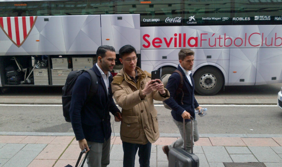 Un aficionado se fotografía con Ramí delante del bus oficial