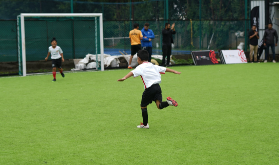 Un niño de la Escuela Turf Up celebra un gol con la camiseta sevillista