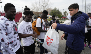 Juanlu entrega unas botas a uno de los refugiados.