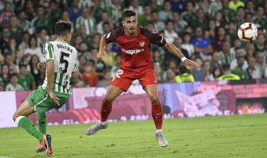 André Silva del Sevilla FC ante el verdiblanco Bartra