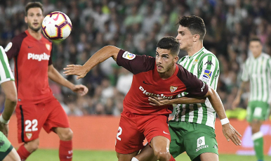 André Silva del Sevilla FC ante el verdiblanco Bartra