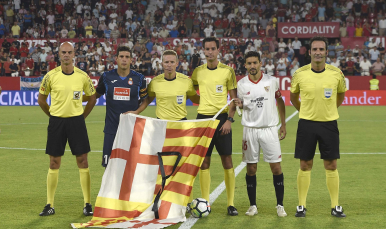 Los capitanes y el cuarteto arbitral con la bandera de Barcelona