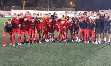 La plantilla del Sevilla Atlético posa con el trofeo ganado la noche del martes en Utrera