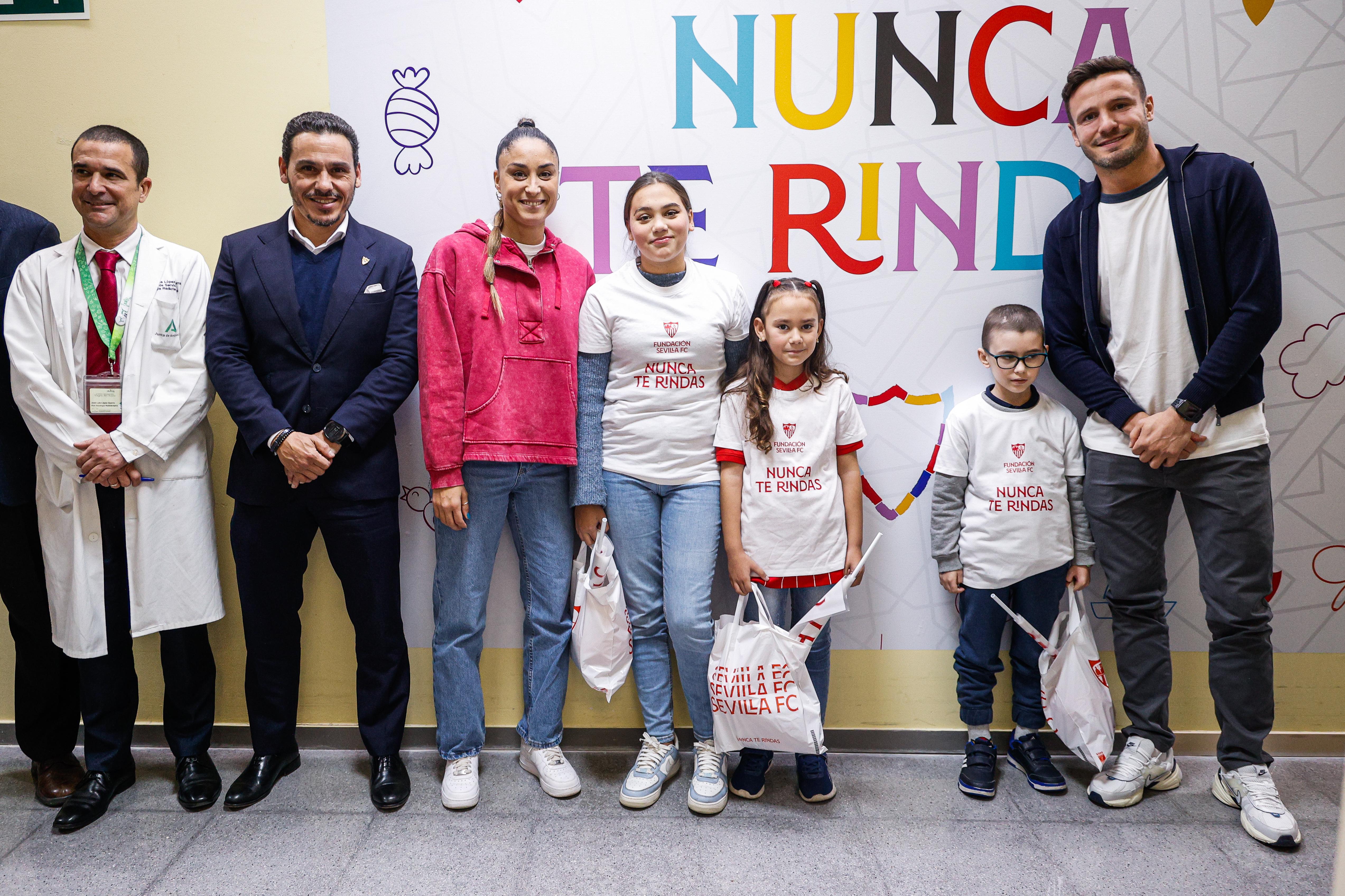 La delegación del Sevilla FC, junto al mural de 'Nunca te rindas' en el Hospital Virgen del Rocío.