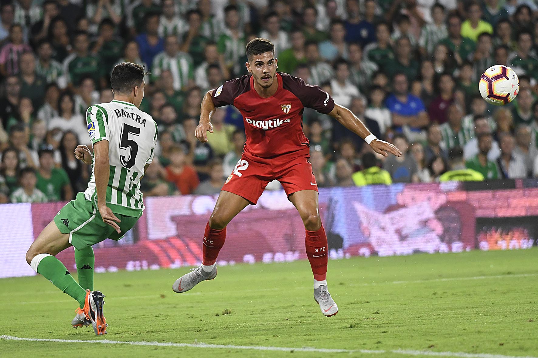 André Silva del Sevilla FC ante el verdiblanco Bartra