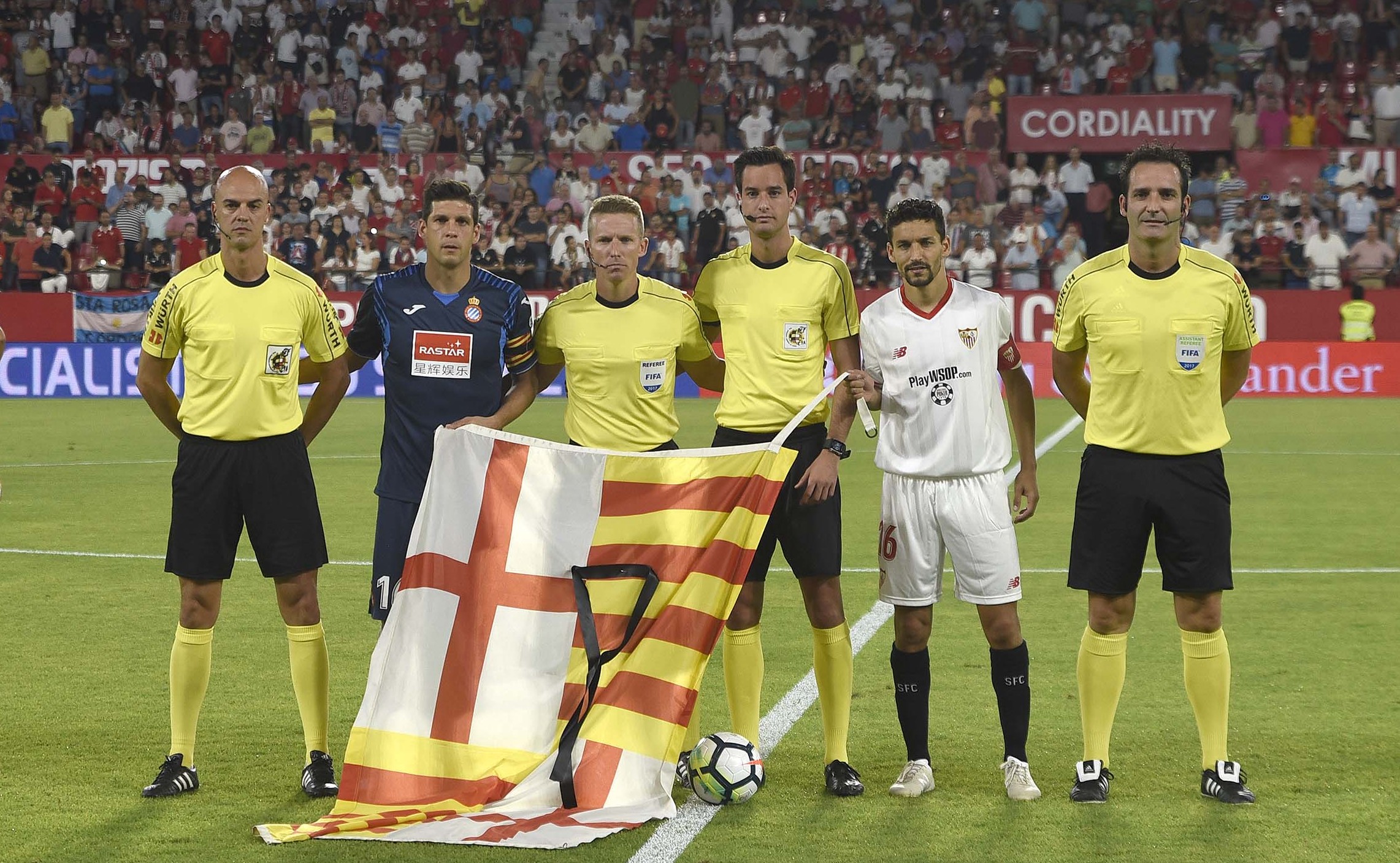 Los capitanes y el cuarteto arbitral con la bandera de Barcelona