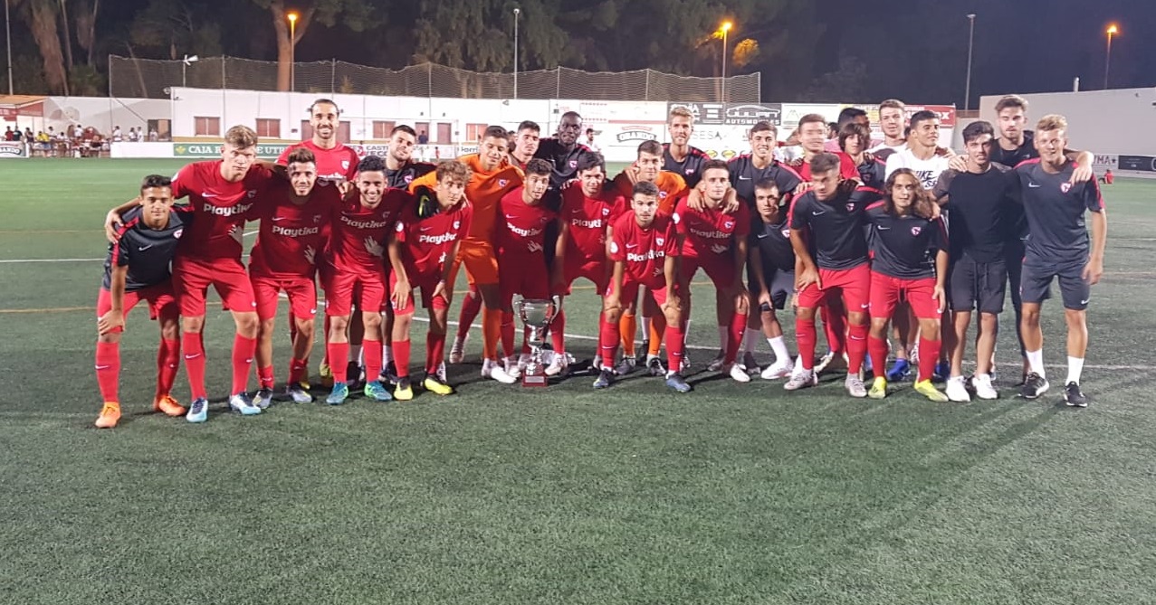 La plantilla del Sevilla Atlético posa con el trofeo ganado la noche del martes en Utrera